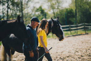Claire regarde un cheval et son cavalier en piste